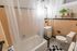 Charming bathroom with vintage peach tile, modern fixtures, and decorative plants for a fresh touch.