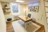 Charming home office featuring a wooden desk, modern chair, and inspiring 'Keep Going' neon sign, complemented by stylish artwork and a cozy window view.