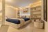Cozy and inviting bedroom with ambient string lights, elegant shelving, and a plush navy blue bed, perfect for relaxation and comfort.