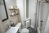 Elegant and modern bathroom with chic floating shelves, stylish sink, and a serene bathtub area.