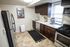 Modern kitchen with sleek stainless steel appliances, dark wood cabinetry, and a cozy breakfast area.