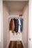Chic closet space with stylish clothing, showcasing organized shelving in a modern apartment.
