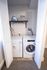 Convenient laundry area with modern washer and dryer, neatly tucked behind white louvered doors, perfect for efficient apartment living.