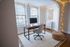 Cozy home office with a modern wooden desk, elegant chair, and ambient string lights, perfect for productivity.