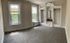 Bright and airy room featuring elegant built-in shelving, carpeted flooring, and large windows with scenic views.