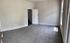 Bright, spacious room with plush carpet and elegant paneled door, filled with natural light from large window.
