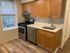 Charming kitchen with sleek wood cabinets, modern stainless steel appliances, and elegant wood flooring.