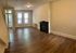 Bright, spacious living area with elegant hardwood flooring and classic fireplace, perfect for modern living.