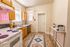 Charming kitchen with wooden cabinets, modern appliances, and elegant decor, highlighted by a playful neon sign.