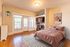 Charming bedroom with large windows, cozy pink bedding, stylish open closet, and elegant decor.