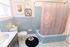 Charming bathroom with vintage blue tiles, artistic wall decor, and a cozy ambiance, perfect for relaxation.