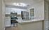 Modern kitchen with sleek stainless steel appliances, elegant white cabinetry, and a stylish granite countertop island.