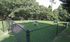 Spacious and secure outdoor dog park with agility obstacles, lush green grass, and shaded areas surrounded by forest, perfect for pet-friendly living.