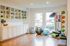 Inviting home gym with ample natural light, featuring vibrant exercise equipment, sleek white cabinetry, and a polished wood floor.