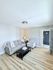Inviting living room with modern gray sofa, stylish patterned armchair, and chic coffee table on elegant wood flooring.