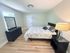 Bright and inviting bedroom with elegant decor, featuring a plush bed, modern dresser, and ambient lighting.