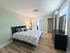 Bright and inviting bedroom with elegant decor, featuring a cozy king-sized bed, stylish nightstand lamp, and natural wood flooring.
