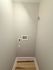 Compact laundry space with modern hookups and sleek wooden flooring, ideal for efficient urban living.