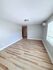 Bright and spacious room featuring sleek wood flooring and modern lighting, perfect for a cozy living area.
