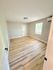 Bright and airy room with sleek hardwood floors, modern light fixture, and large window offering natural light.