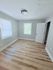 Bright, freshly painted room with elegant wood flooring and ample natural light, ready to be personalized to your style.