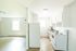Bright and modern kitchen with sleek white appliances and spacious open floor plan, ideal for entertaining.