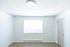 Bright and airy empty room with large window and modern light fixture, perfect for personalization.