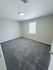Inviting bedroom with plush carpeting and soft natural light pouring through a window, creating a serene and cozy atmosphere.