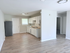 Bright and spacious apartment featuring a modern kitchen with sleek white cabinetry, an inviting living area with stylish wooden floors, and ample natural light.