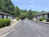 Charming apartment complex with lush greenery, ample parking, and serene surroundings.