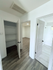 Bright apartment interior showcasing elegant laminate flooring, a spacious closet, and modern bathroom entry.