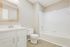 Bright, modern bathroom with a sleek vanity, large mirror, and a pristine bathtub.