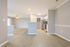 Bright open-plan apartment showcasing a modern kitchen, sleek hardwood floors, and a welcoming living area with natural light.
