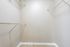 Spacious walk-in closet with sleek wire shelving and stylish hardwood flooring, perfect for ample storage and organization.