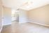 Bright and spacious room with elegant wood flooring and modern ceiling fan, leading to a sleek bathroom with stylish fixtures.
