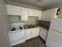 Charming kitchen with modern white cabinets, granite countertops, and clean appliances, perfect for culinary creativity.
