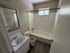 Cozy bathroom with a classic white bathtub, sleek vanity, and elegant wall mirror, offering a tranquil, well-lit space.
