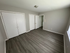 Spacious bedroom with elegant wood flooring, ample closet space, and natural light from a large window.