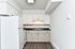 Modern kitchen with sleek white cabinetry, spacious countertops, and a contemporary refrigerator in a bright apartment.