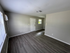 Bright and spacious living area with modern gray flooring and ample natural light, perfect for a comfortable home environment.