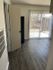 Bright apartment featuring sleek wood flooring, open layout, and large sliding glass doors leading to a serene outdoor space.