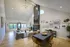 Inviting open-plan living room with high ceilings, modern chandelier, cozy seating area, and vibrant wall art.