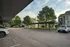 Charming apartment complex with covered parking and lush greenery in a tranquil setting.