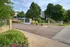 Inviting entrance to Quail Cove apartments showcasing lush greenery and vibrant flowers for a serene living environment.
