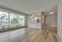 Bright and spacious open-concept apartment with expansive windows, modern kitchen, and elegant wood floors.
