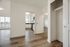 Bright modern apartment featuring a sleek kitchen, open living space with wood flooring, and large windows offering stunning city views.