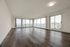 Expansive modern living room with elegant hardwood floors, floor-to-ceiling windows, and panoramic city views.