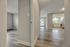Inviting open-layout apartment with sleek hardwood floors, a bright kitchen, and a sunlit living area with large windows.