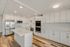 Bright and modern kitchen with sleek stainless steel appliances, an elegant white island, and ample cabinetry in a spacious open layout.