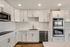 Modern kitchen showcasing sleek white cabinetry, stainless steel appliances, and elegant subway tile backsplash.